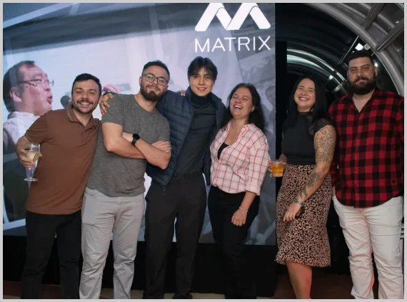 Time da Matrix Energia diante do telão da empresa